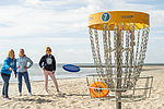 Menschen spielen Discgolf am Strand von Kellenhusen, Ostsee. 