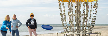 Menschen spielen Discgolf am Strand von Kellenhusen, Ostsee.  - zum Artikel 'Kostenlose Freizeiterlebnisse in Schleswig-Holstein'