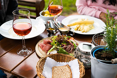 Angerichteter Tisch mit Wein, Spargel und Brot