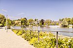Die breite Eutiner Seepromenade direkt am Seeufer mit Blick auf das Wasser, im Hintergrund das Hotelgebäude der SeeLoge.